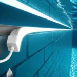 IP68 rated waterproof LED strip light mounted on a teal blue tiled pool wall in a wet underwater environment, with visible waterproof connector and cable, demonstrating submersible LED strip installation for swimming pools
