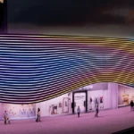 Commercial retail building exterior at night covered in dense parallel wavy lines of multicolor neon LED strip lights in white, cyan, yellow and orange tones, creating a dramatic flowing wave pattern across the entire facade with pedestrians visible below