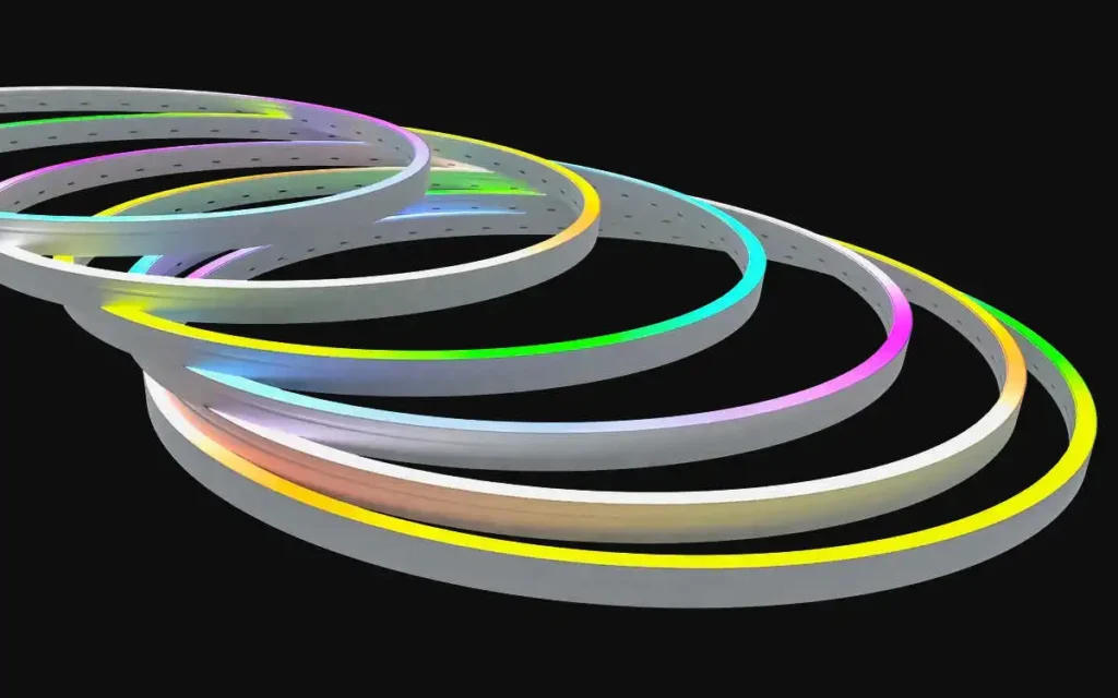 Abstract sculpture of intertwined grey rings with neon-colored edges on a black background, suggesting motion and loops of light.