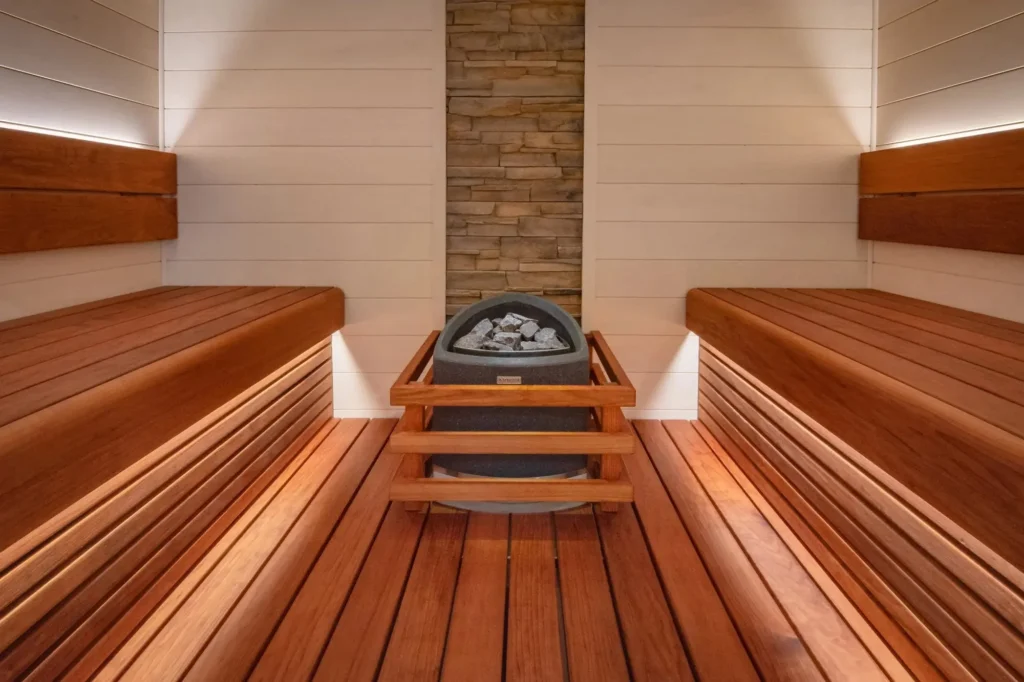 Warm white LED strip lights installed under wooden sauna bench creating a relaxing amber glow