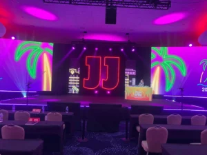 Complete event stage lighting design featuring custom LED signs and RGBW strips managed by DMX lighting controllers.