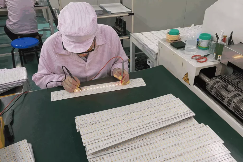 Factory worker conducting lighting brightness testing on LED circuit boards, raw component inspection procedure for manufacturing RGB silicone LED neon flex commercial decorative lighting