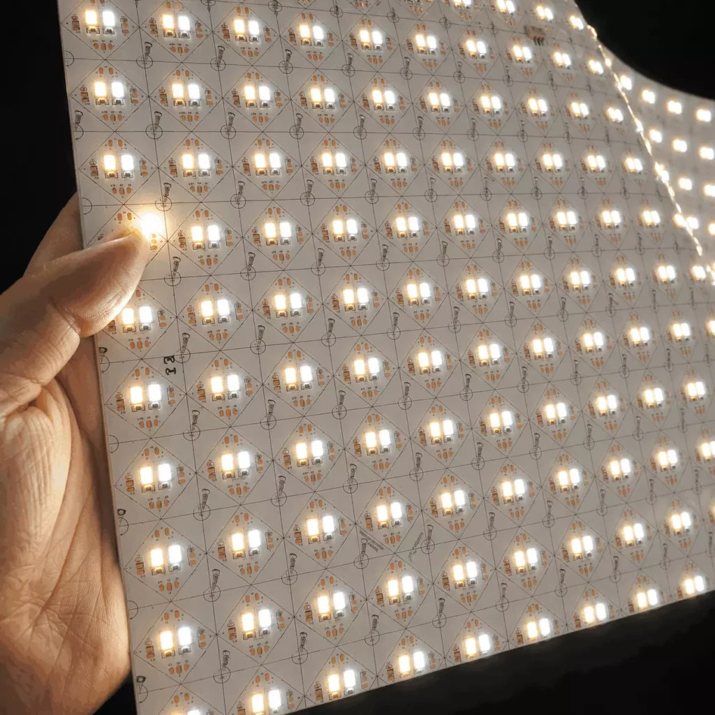 Hand holding a flexible LED sheet panel showing the SMD2835 LED array of a CCT tunable white backlight sheet