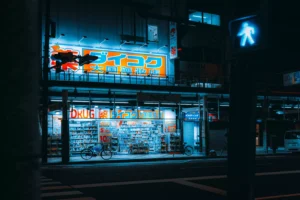 Large outdoor LED neon flex facade signage lighting up a multi-story drugstore building along a city street at night, illustrating durable UV resistant silicone neon flex for facade lighting and commercial building exteriors.